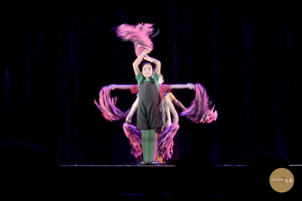 Trio de bailarinas infantis em performance teatral, expressando ritmo e expressão corporal. Fotografia profissional de espetáculo feita pelo Studio LA.