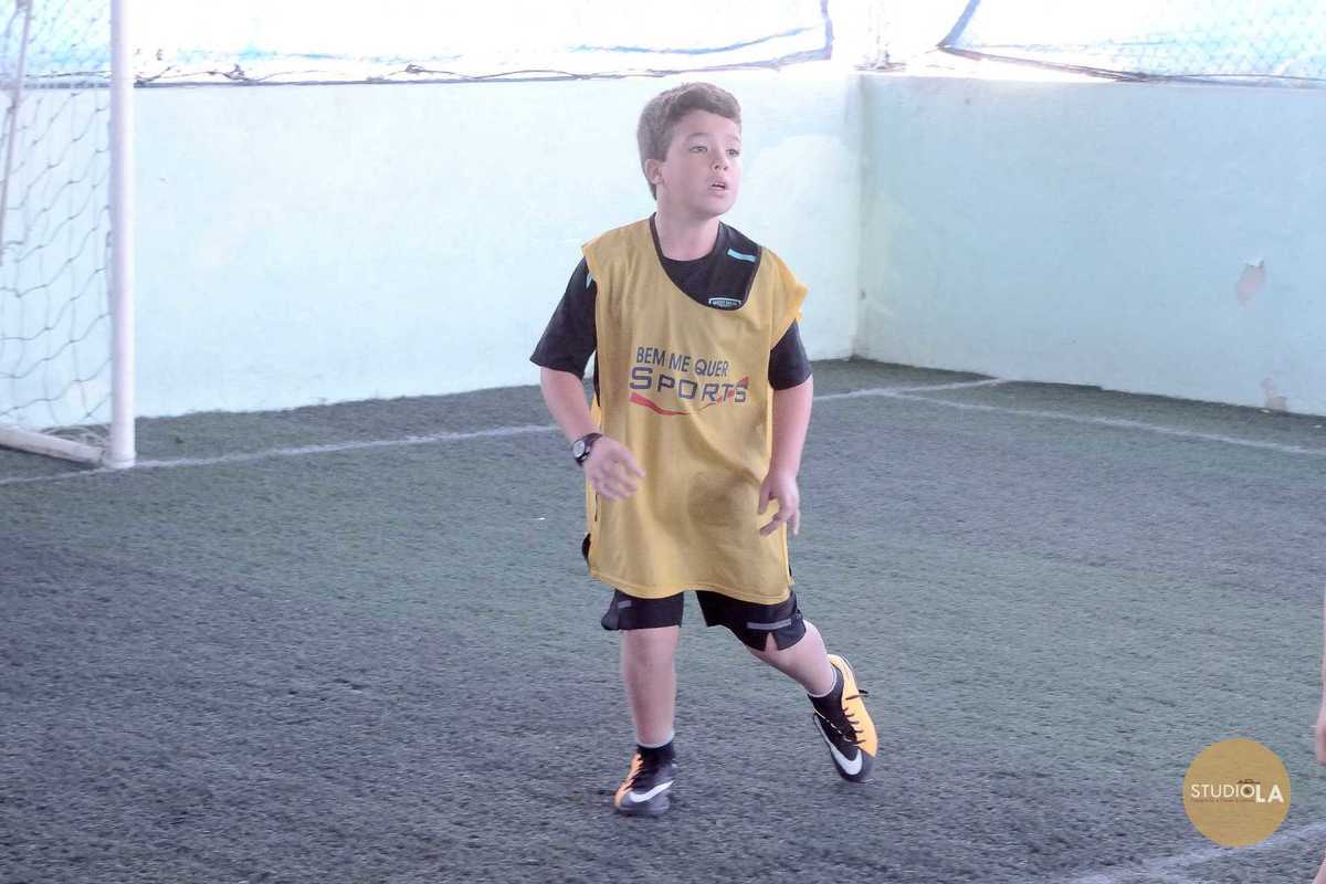 Menino jogando futebol na quadra do Buffet Bem Me Quer em SP — fotografia profissional de festa infantil feita pelo Studio LA.