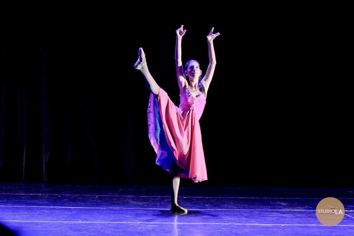 1.	Fotografia de apresentação de dança em teatro – Bailarina infantil em pose clássica de balé no palco, registrada pelo Studio LA em São Paulo. Imagem artística que transmite emoção e delicadeza do espetáculo.