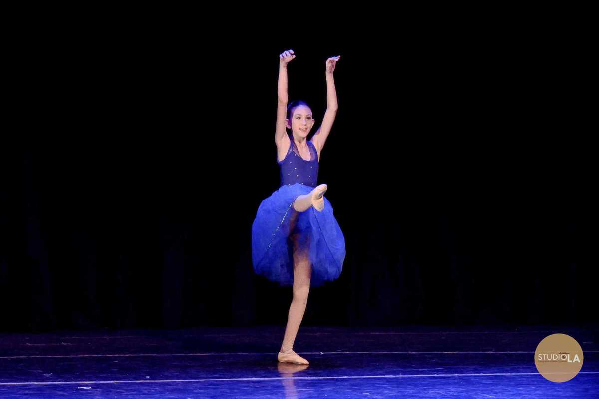 2.	Apresentação de balé infantil em teatro – Fotografia profissional do Studio LA captando o movimento gracioso de jovem bailarina durante espetáculo em São Paulo.