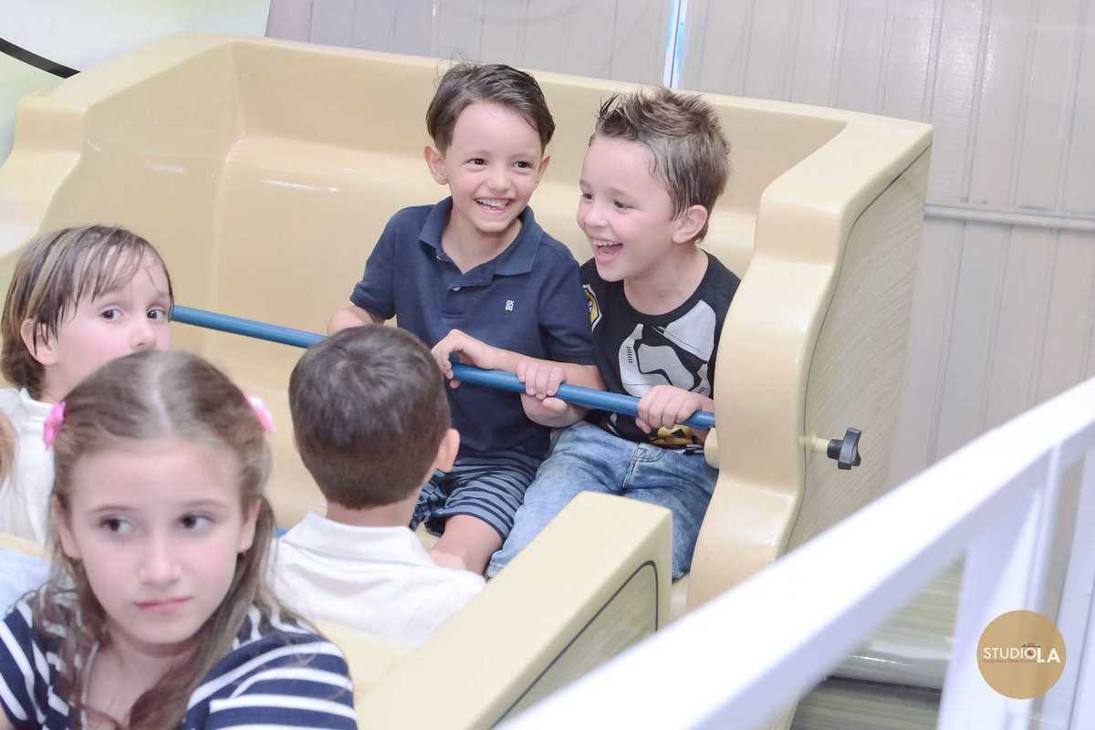 Amigos rindo juntos em brinquedo do buffet infantil durante festa de aniversário — Fotografia espontânea de festa infantil em São Paulo por Studio LA.