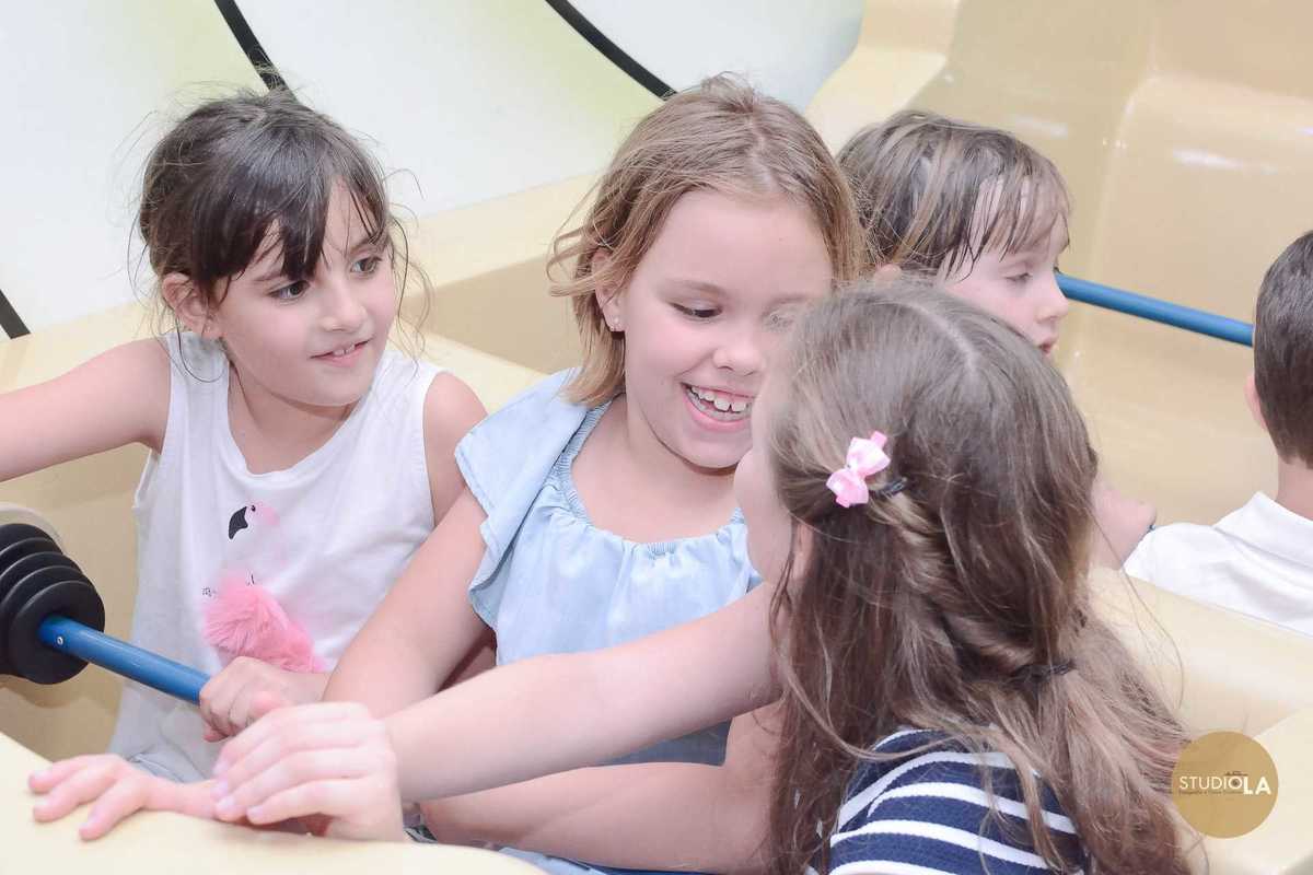 Crianças brincando e sorrindo em brinquedo coletivo do buffet durante aniversário infantil — Fotografia documental de festa infantil por Studio LA.