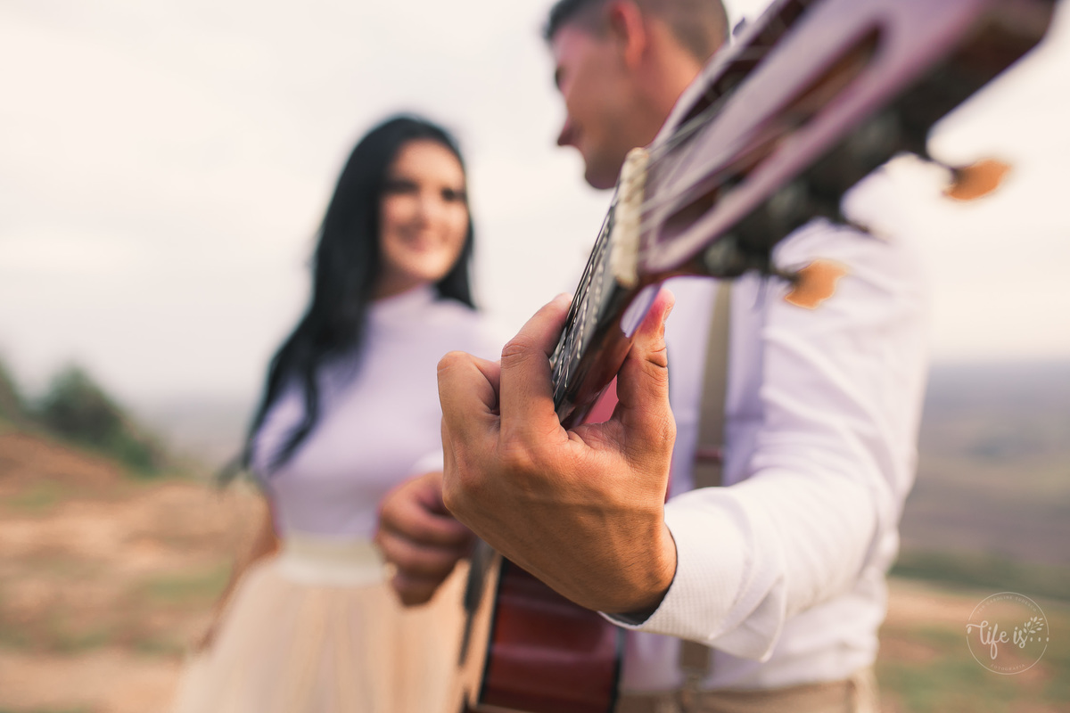 Noivos no ensaio pré-wedding cantando com violão