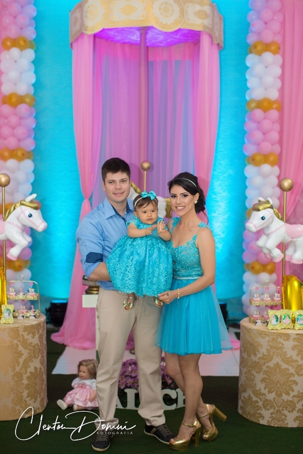 FAMÍLIA EM FRENTE DA DECORAÇÃO DE CAVALOS NA FESTA DE UM ANINHO