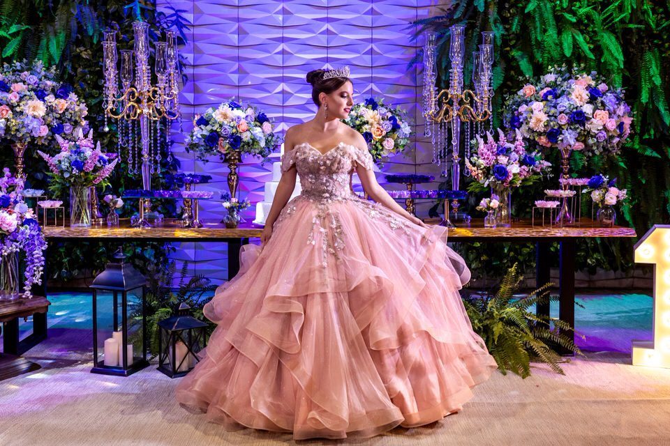 Ensaio fotográfico da debutante Roberta no dia da sua festa de 15 anos, em frente à mesa de doces decorada. Retrato com vestido de princesa por fotógrafo de debutante em São Paulo.