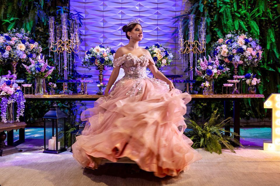 Debutante Roberta girando com seu vestido rosa durante ensaio fotográfico na sua festa de 15 anos. Foto com movimento por fotógrafo de debutante em São Paulo.