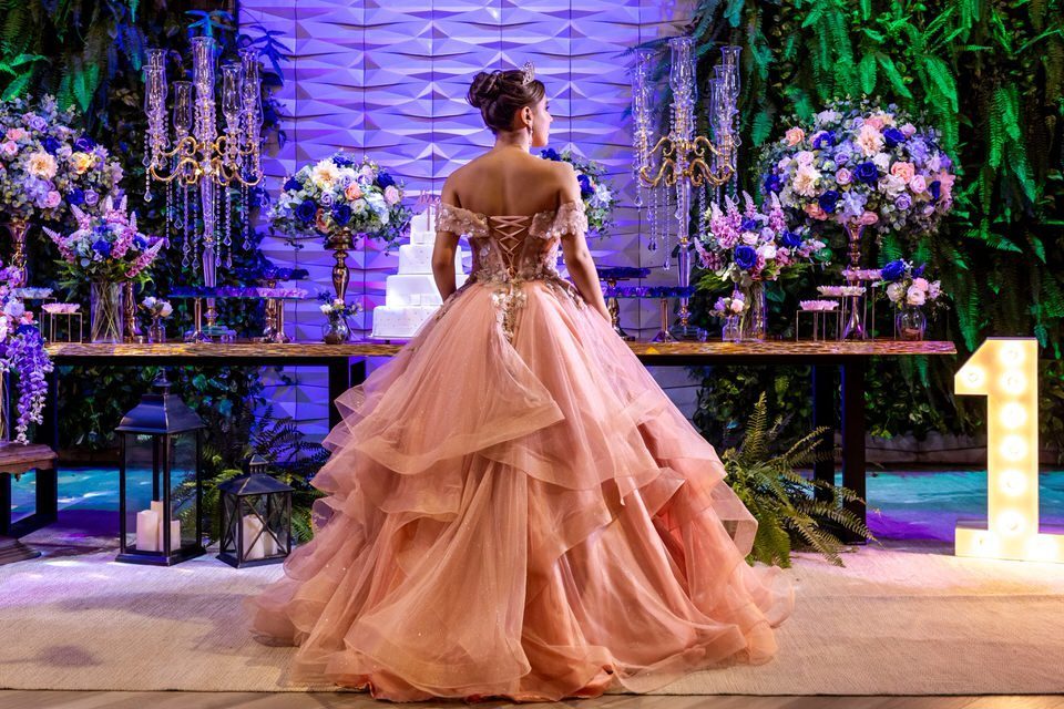 Debutante Roberta de costas, mostrando os detalhes do vestido rosa em seu ensaio de 15 anos no Espaço Illumina. Fotografia de festa de 15 anos em São Paulo.