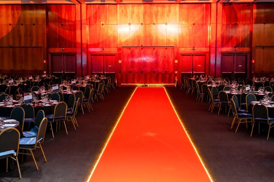 Fotógrafo para eventos jurídicos registra o salão de premiação do BRALLAW Awards no WTC, com mesas de jantar e múltiplos telões preparados para os convidados.