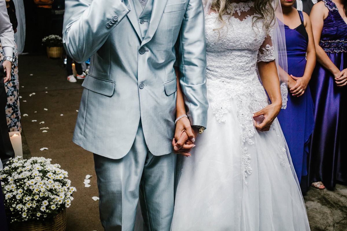 Noivos de mãos dadas em momento de oração.