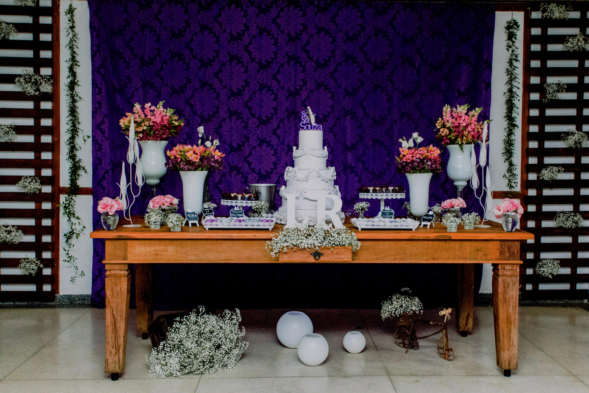 Mesa do bolo de casamento em tons de roxo.