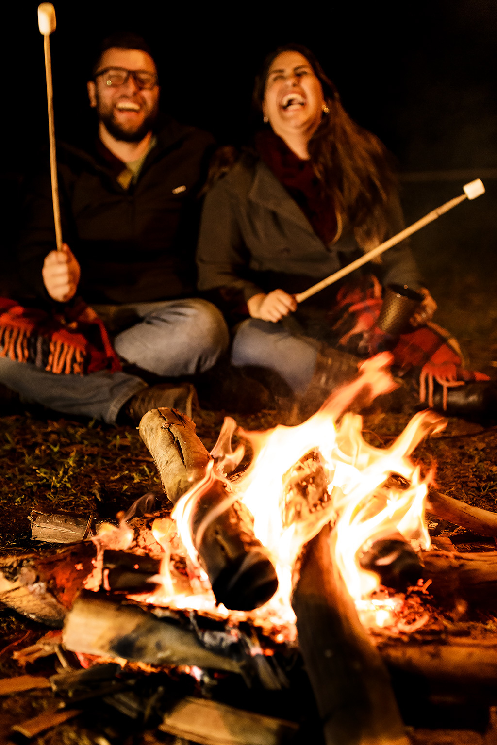 Casal abraçado na fogueira casal no camping