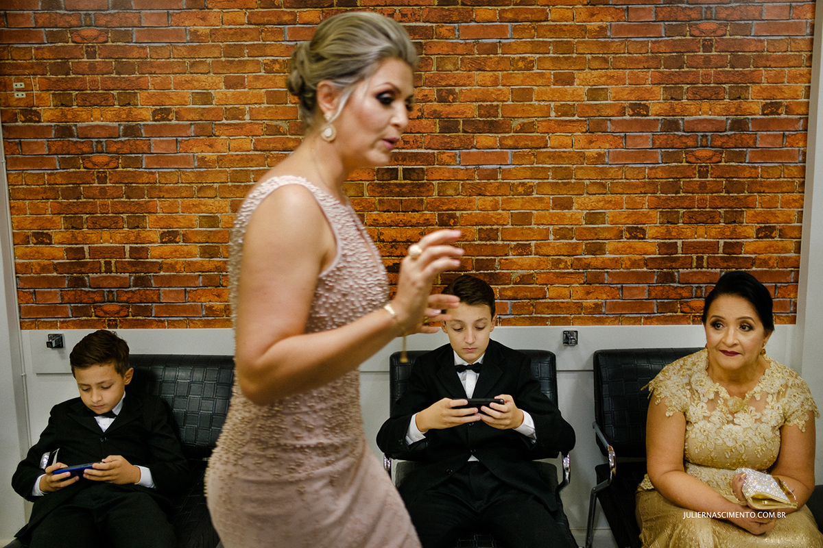 pajem de casamento mexendo em celular enquanto espera a noiva