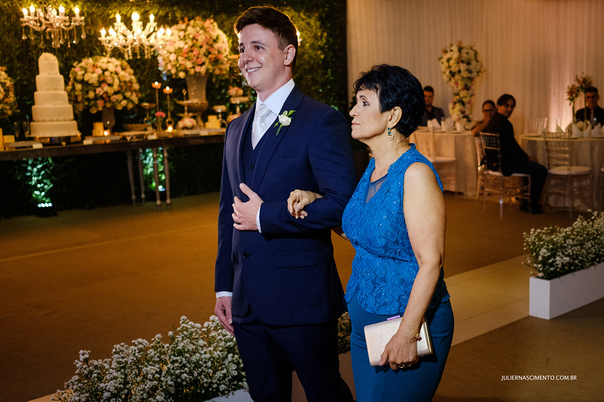 fotografia da entrada do noivo junto com sua mãe no cerimonial Vilani em Vitória-ES ele usa terno do Ricardo Almeida.