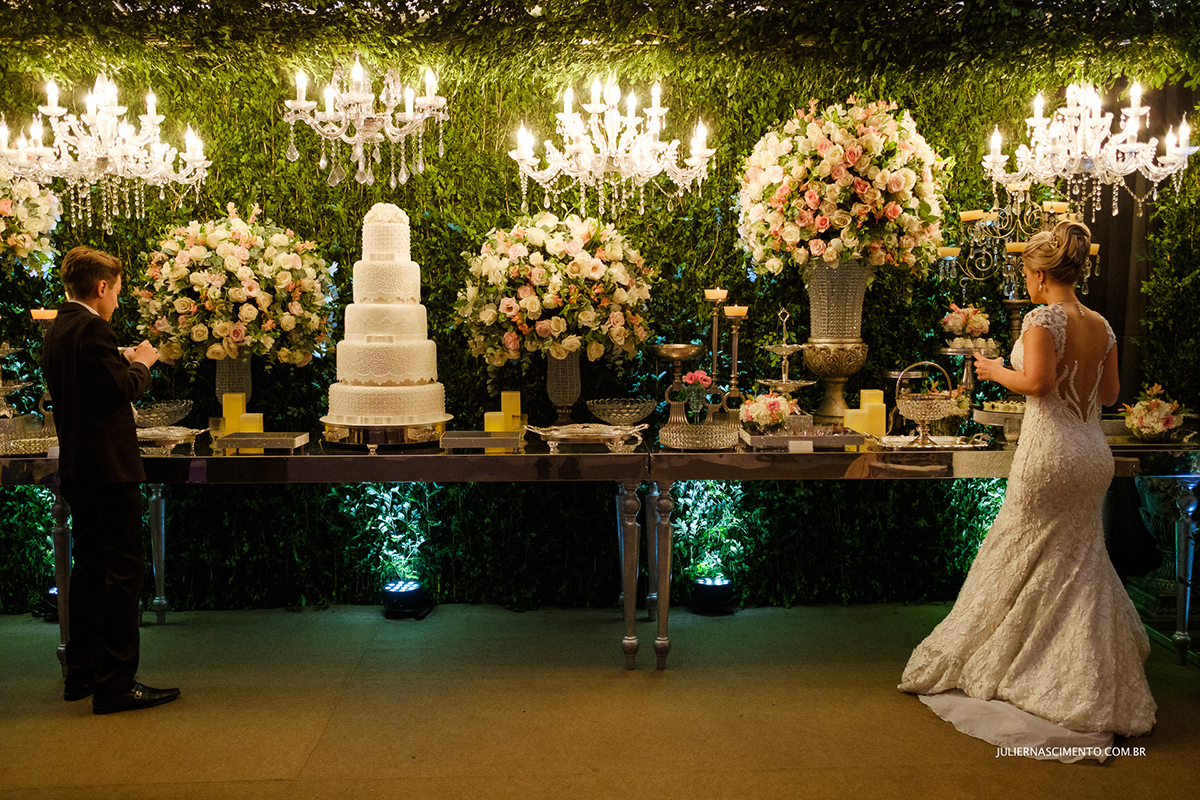 A noiva e seu pajem comem na mesa de doces e bolo de casamento na decoração da Art's eventos em Vitória-ES.