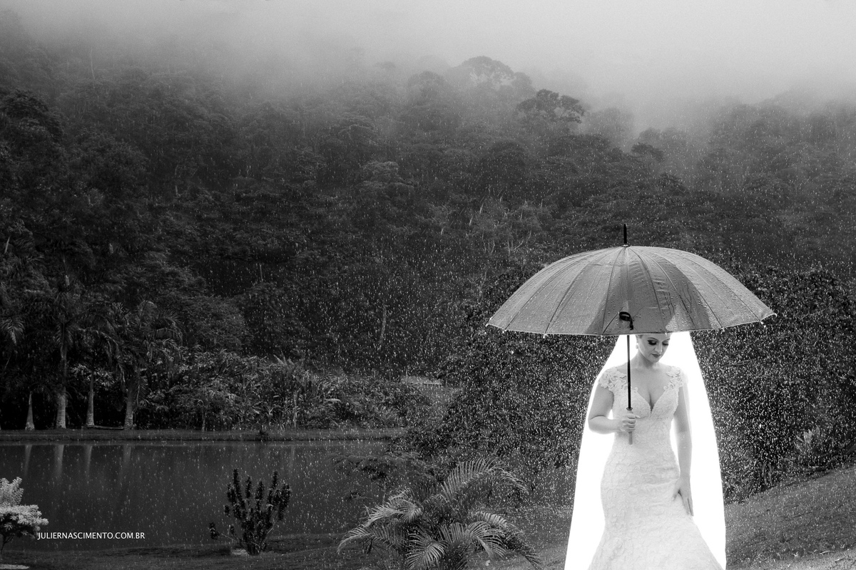 foto de noiva com sombrinha na chuva em ensaio externo de pós casamento na pousada santa lucia em santa teresa-es