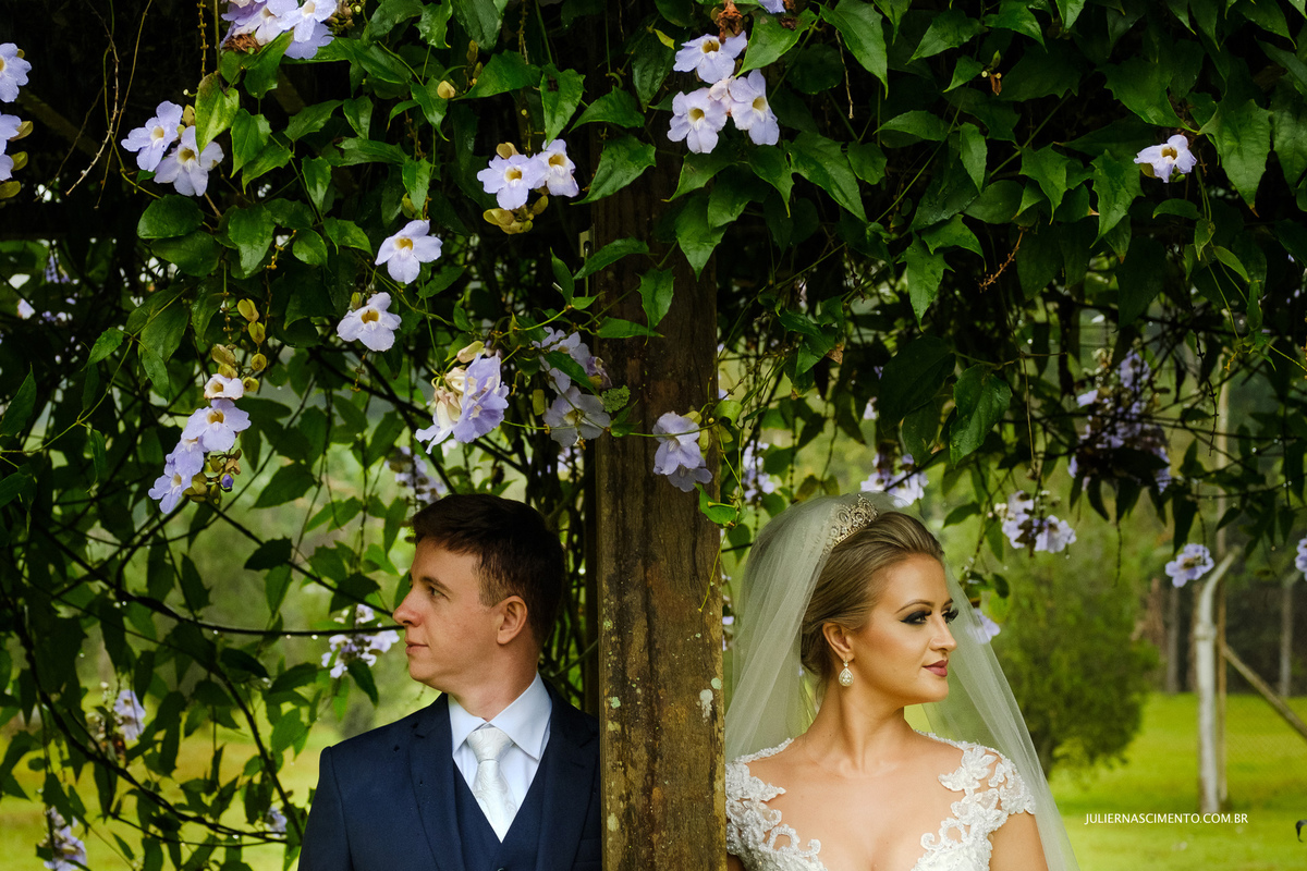foto de noivos debaixo de flores no ensaio externo de pós casamento na pousada santa lucia em santa teresa-es