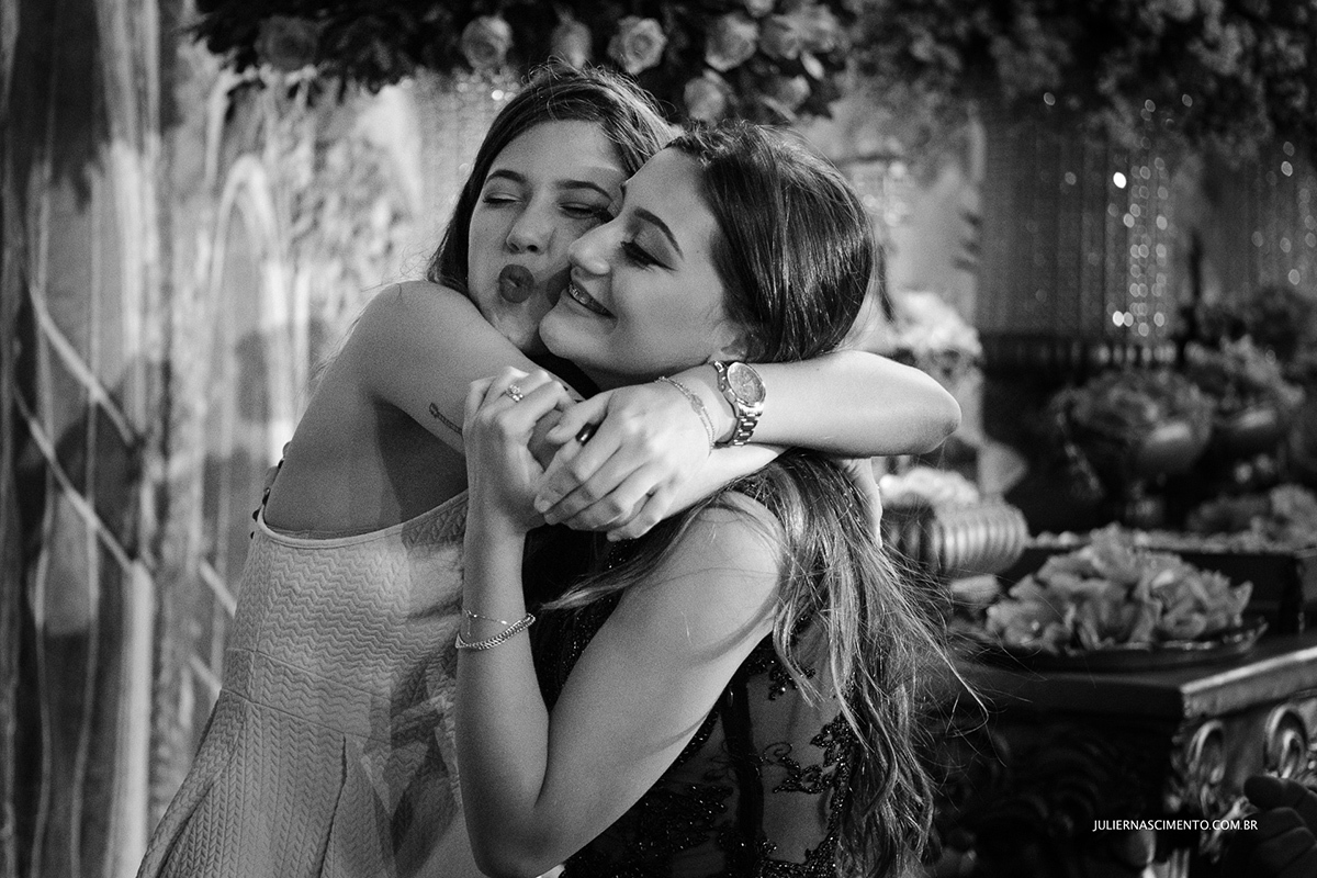amiga abraçando a debutante na festa de quinze anos.