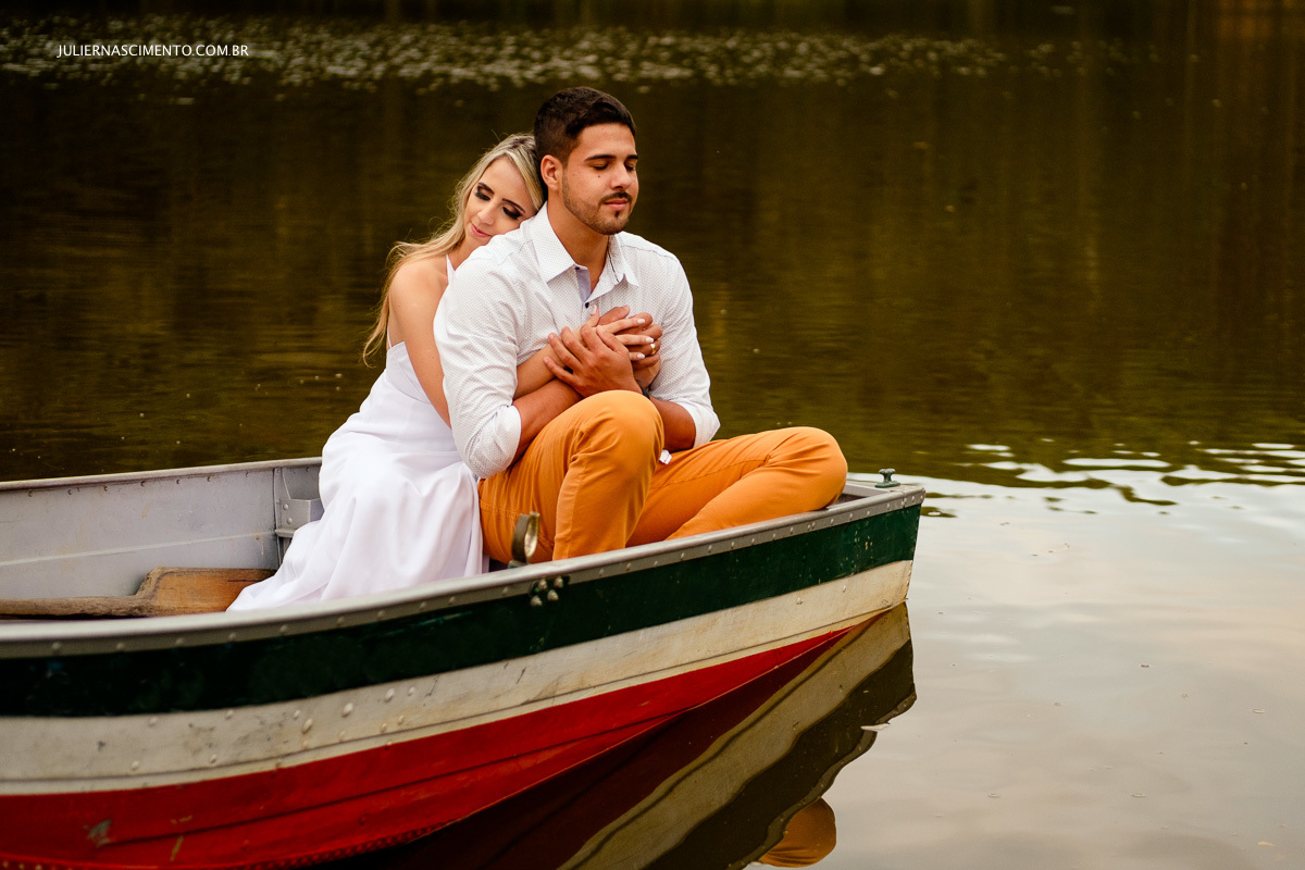 noivos em um barco dentro de um lago na sessão fotografica