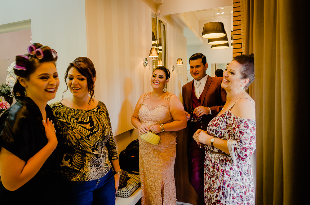 Fotografia na noiva no making of no dia do casamento no salão de beleza no dia da noiva com seu irmão, cunhada e amigos em Maringá PR