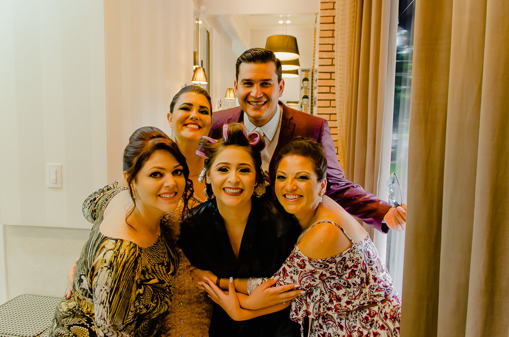 Fotografia na noiva no making of no dia do casamento no salão de beleza no dia da noiva com seu irmão, cunhada e amigos em Maringá PR
