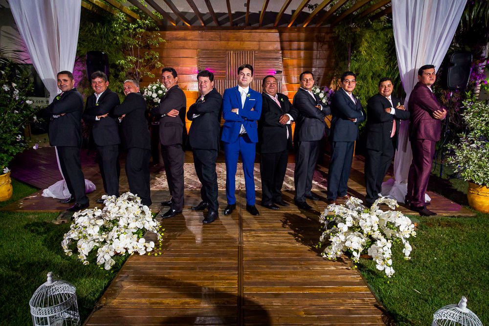 Fotografia da recepção ou festa de casamento do noivo de terno azul e gravata borboleta branca com os padrinhos no espaço a céu aberto do evento em Maringá PR