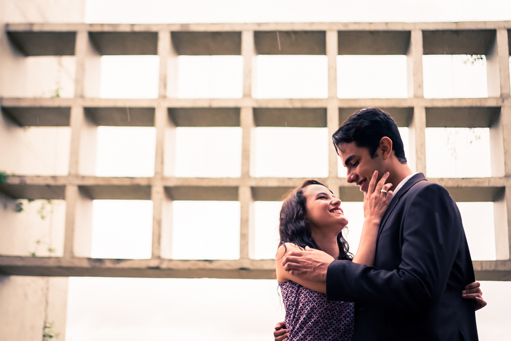 Fotografia do casal, o noivo e a noiva, no ensaio pre casamento, wedding se olhando apaixonados. Ensaio fotográfico no Parque Vila Lobos, Alto de Pinheiros, São Paulo, SP em uma dia de muita chuva.