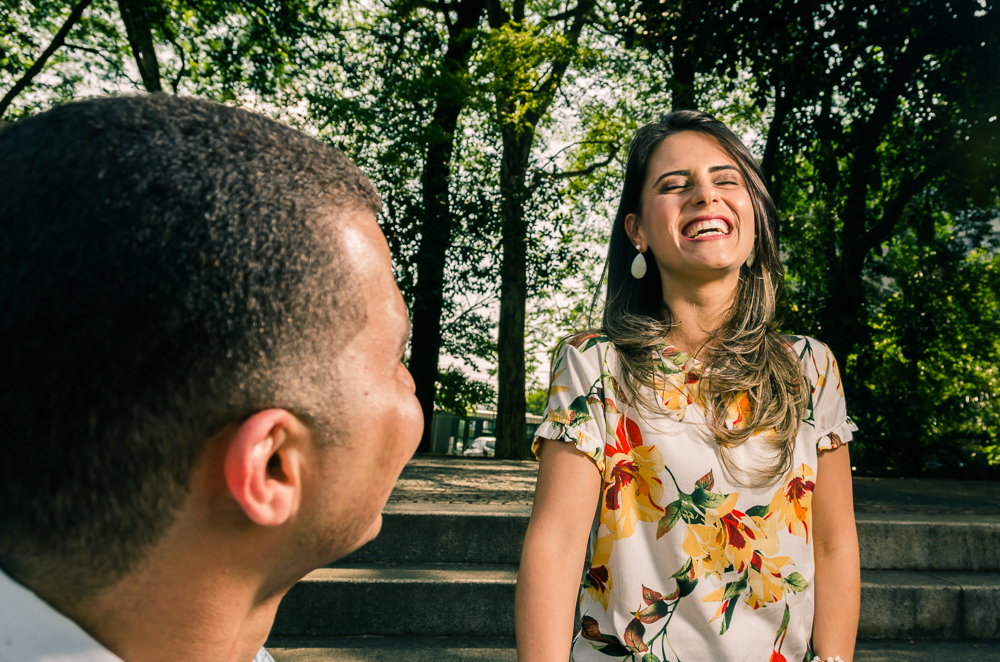 Ensaio do ensaio pre casamento dos noivos se olhando e dando risadas em um dia de sol. O noivo e a noiva estão no Parque do Ipiranga, Bairro Ipiranga, São Paulo, Brasil.