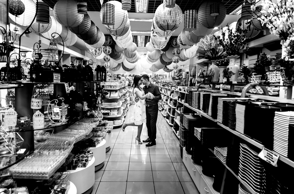 Foto em preto e branco, pb, do ensaio pre casamento, wedding, do casal de noivos em uma loja de produtos orientais. O noivo e a noiva estão no Bairro Liberdade, São Paulo, Brasil.