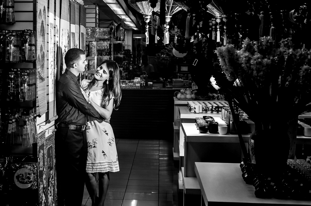 Foto em preto e branco, pb, do ensaio pre casamento, wedding, do casal de noivos em uma loja de produtos orientais. O noivo e a noiva estão no Bairro Liberdade, São Paulo, Brasil.