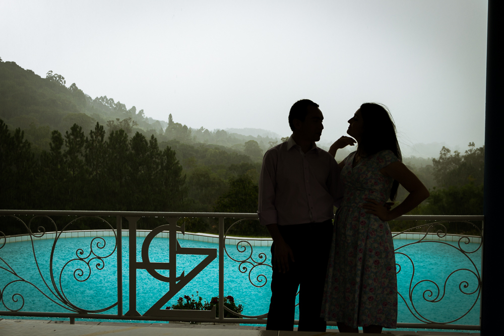 Foto do ensaio pre wedding, casamento, do casal de noivos. ao ar livre, o noivo de terno, a noiva de vestido no Hotel Capo Zorial com piscina e monte ao fundo no Recanto do Maestro em São João do Polêsine, RS, próximo de Santa Maria, RS