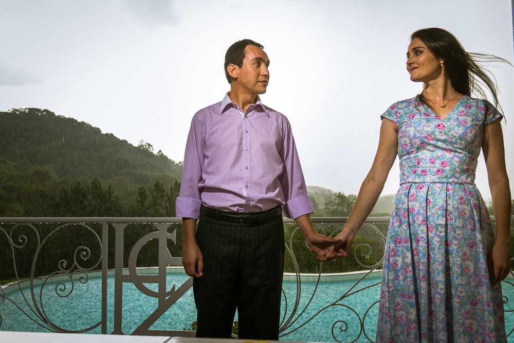 Foto do ensaio pre wedding, casamento, do casal de noivos. ao ar livre, o noivo de terno, a noiva de vestido no Hotel Capo Zorial com piscina e monte ao fundo no Recanto do Maestro em São João do Polêsine, RS, próximo de Santa Maria, RS