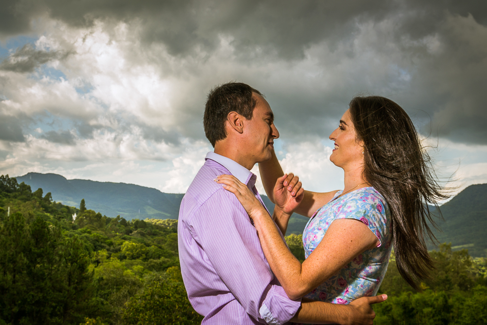 Foto do ensaio pre wedding, casamento, do casal de noivos. ao ar livre, o noivo de terno, a noiva de vestido no Hotel Capo Zorial com piscina e monte ao fundo no Recanto do Maestro em São João do Polêsine, RS, próximo de Santa Maria, RS