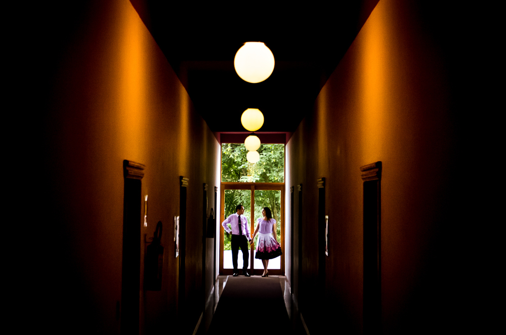 Foto do ensaio pre wedding, casamento, do casal de noivos no corredor do hotel, o noivo de terno, a noiva de vestido no Hotel Capo Zorial com piscina e monte ao fundo no Recanto do Maestro em São João do Polêsine, RS, próximo de Santa Maria, RS