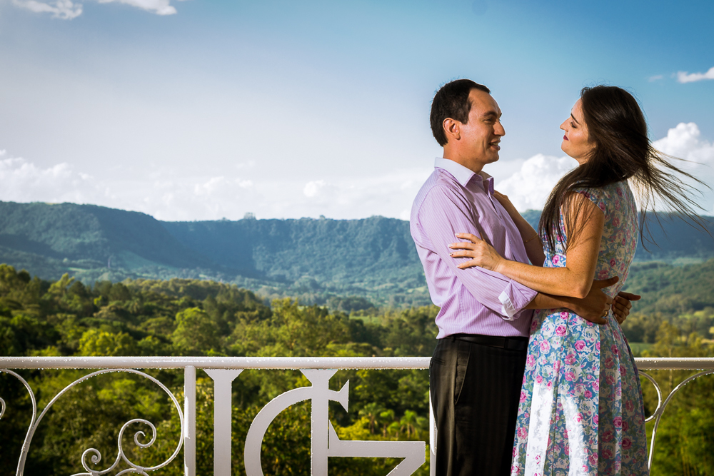Foto do ensaio pre wedding, casamento, do casal de noivos. ao ar livre, o noivo de terno, a noiva de vestido no Hotel Capo Zorial com piscina e monte ao fundo no Recanto do Maestro em São João do Polêsine, RS, próximo de Santa Maria, RS