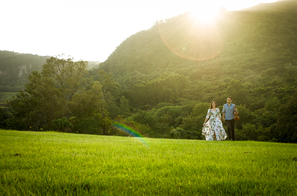 Foto do ensaio pre wedding, casamento, do casal ao ar livre com sol e céu azul no Hotel Capo Zorial com piscina e monte ao fundo no Recanto do Maestro em São João do Polêsine, RS, próximo de Santa Maria, RS