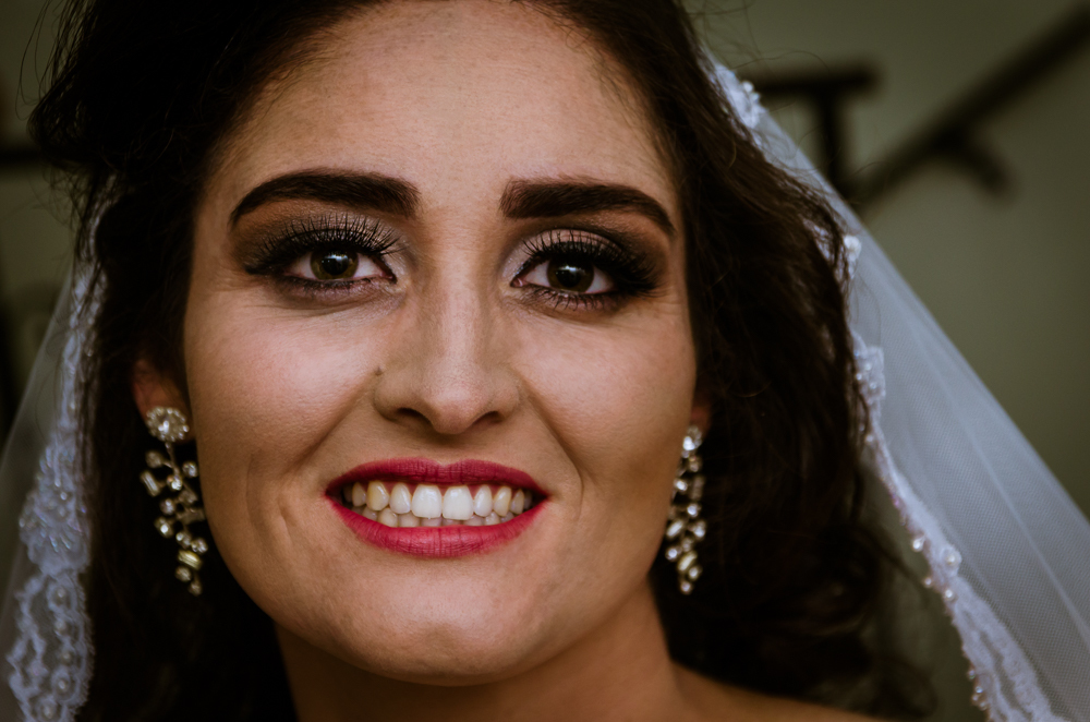 Foto do ensaio making ok na noiva no salão de beleza Centher Hair no dia da noiva fazendo o penteado e maquiagem. Retrato da noiva pronta sorrindo, de baton, brincos, véu e vestido. Em Santa Maria, RS