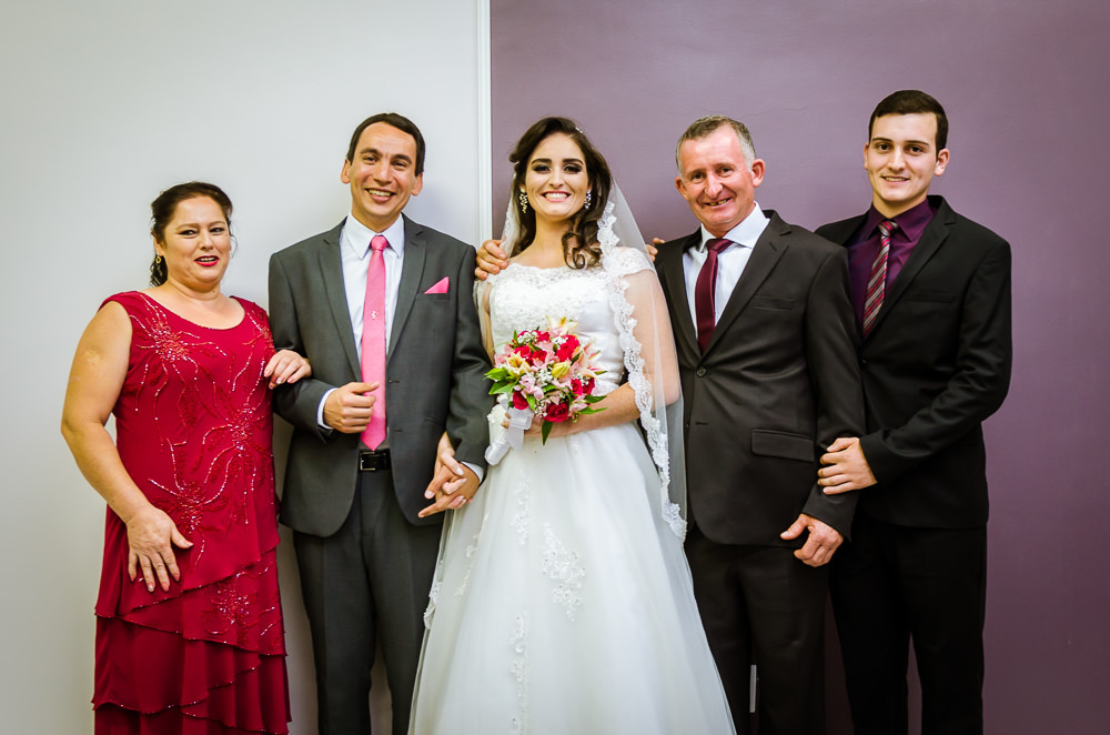 Foto da cerimônia de casamento no Salão do Reino das Testemunhas de Jeová, JW, em Santa Maria, RS. Retrato oficial posada dos noivos com a família da noiva, pai, mãe e irmão.