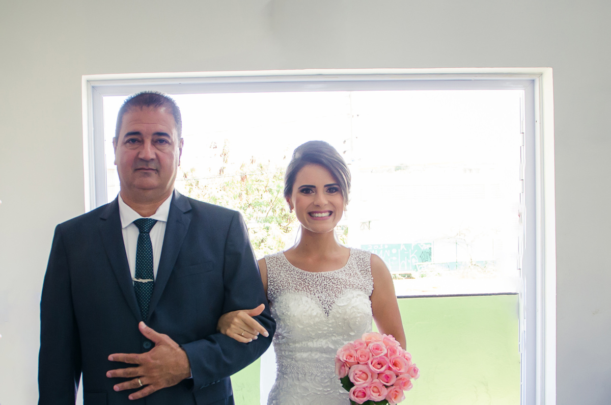 Fotografia da noiva de vestido branco na entrada da noiva para cerimônia de casamento com o pai em Cajamar, São Paulo