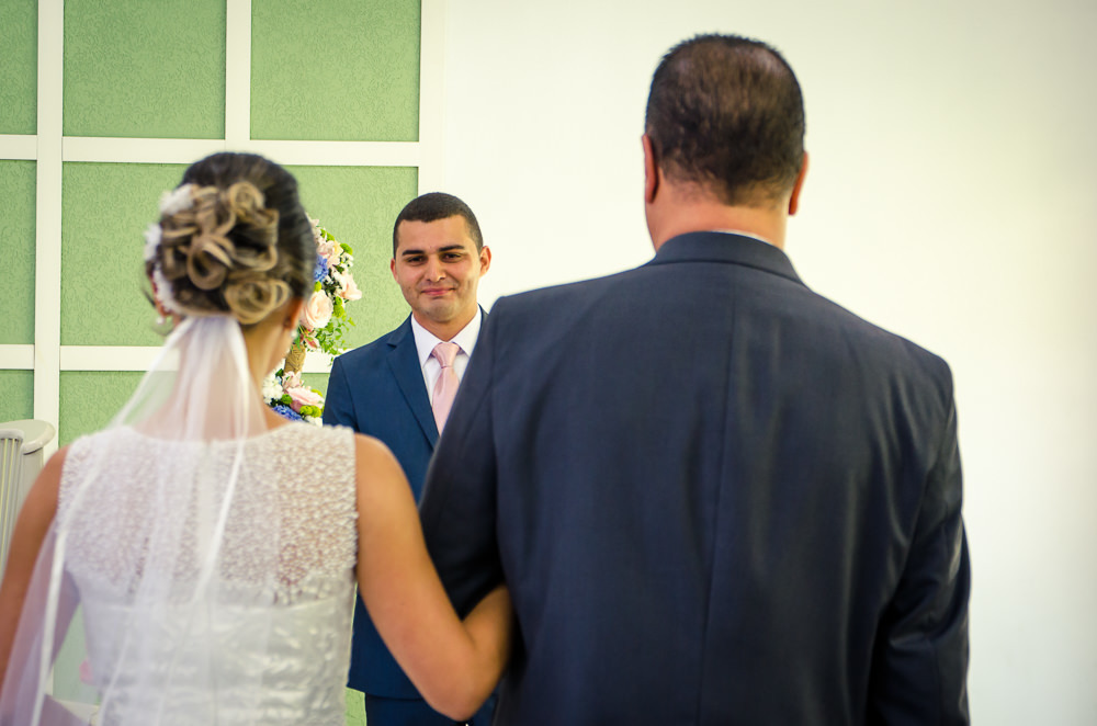 Fotografia da noiva de vestido branco na entrada da noiva para cerimônia de casamento com o pai em Cajamar, São Paulo