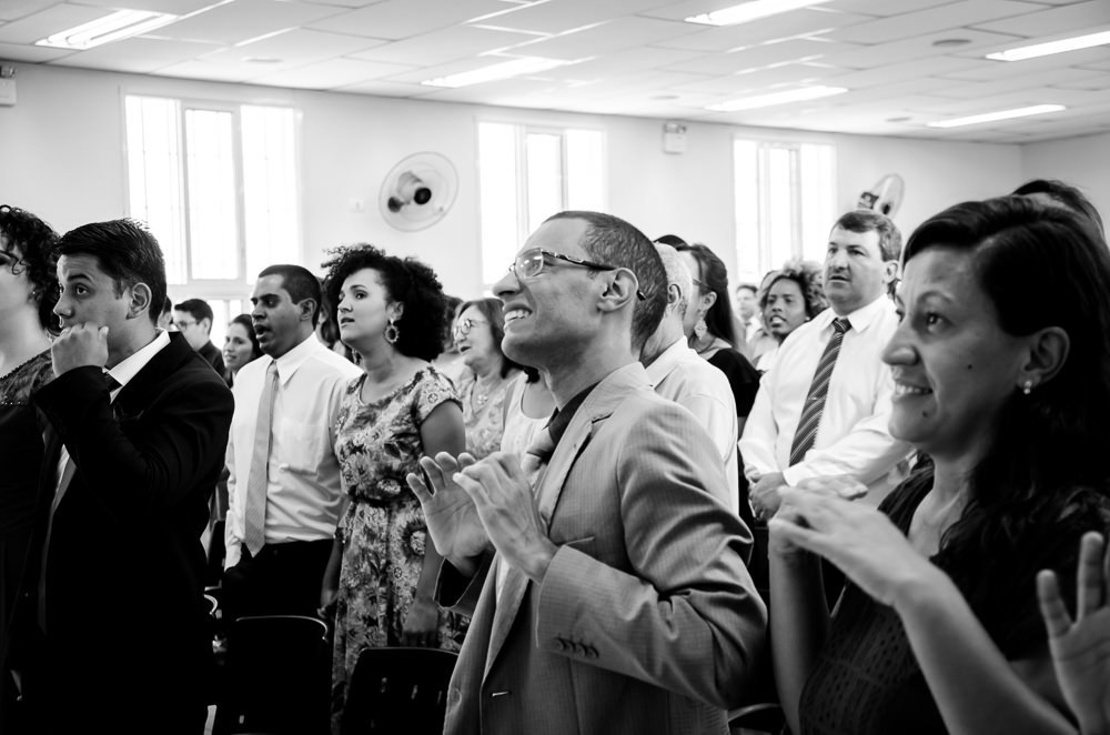Fotografia da cerimônia de casamento dos convidados do noivo e da noiva, noivos, todos cantando o cântico, e os surdos cantando em Língua Brasileira de Sinais, Libras, em Cajamar, São Paulo