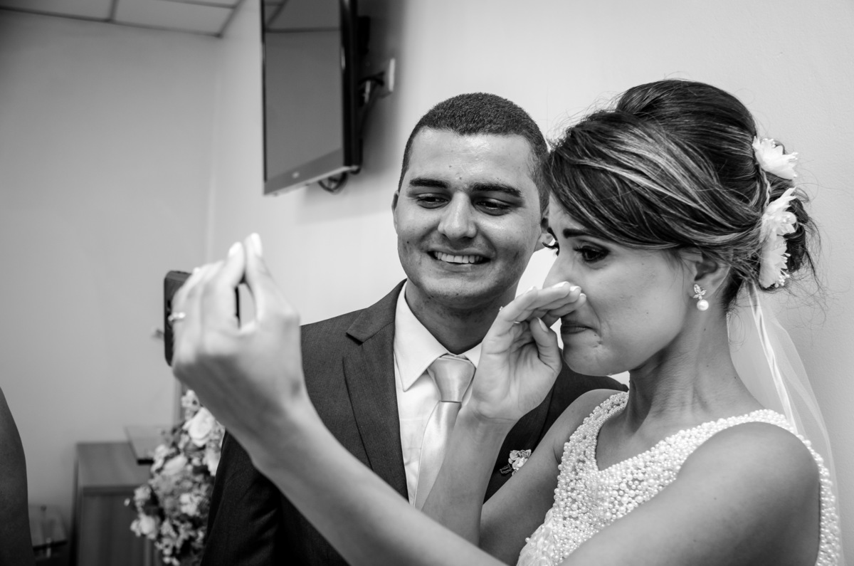 Foto após a cerimônia de casamento em Preto e Branco, WB, PB, dos noivos sendo cumprimentados pelo Whatsapp, a noiva está chorando de emoção em Cajamar, São Paulo 