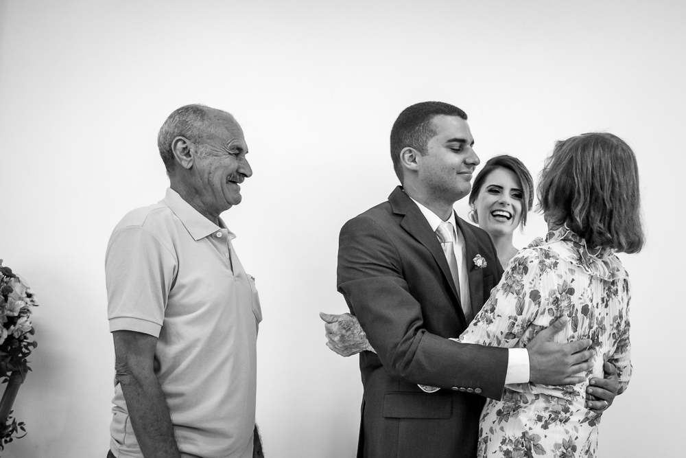 Foto em Preto e BRanco, PB, WB, dos avós do noivo abraçando com alegria o neto e a noiva em Cajamar, Sâo Paulo