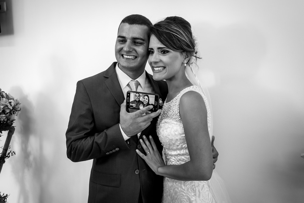 Foto após a cerimônia de casamento em Preto e Branco, WB, PB, dos noivos sendo cumprimentados pelo Whatsapp, a noiva está chorando de emoção em Cajamar, São Paulo 