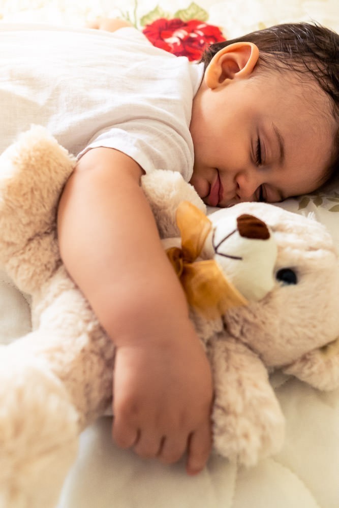 Fotografia Documental de Família. Foto da rotina da família com seu filho criança bebê, mostrando a essência a história da família.  Foto em Barueri, SP. Bebê criança dormindo junto com ursinho de pelúcia