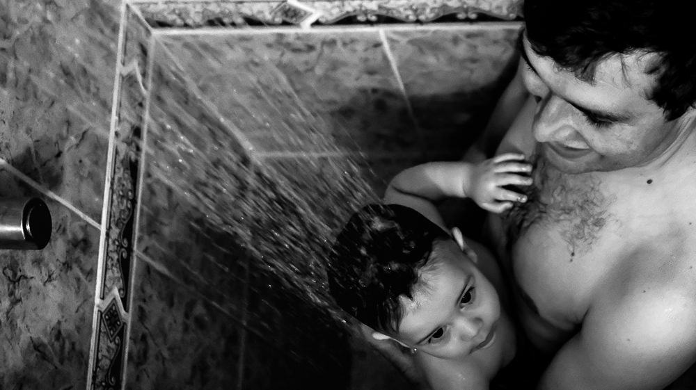 Fotografia documental de Família, Filho com o pai tomando banho no chuveiro, foto em PB, preto e Branco. Carinho do papai com o filho em Barueri, SP, São Paulo