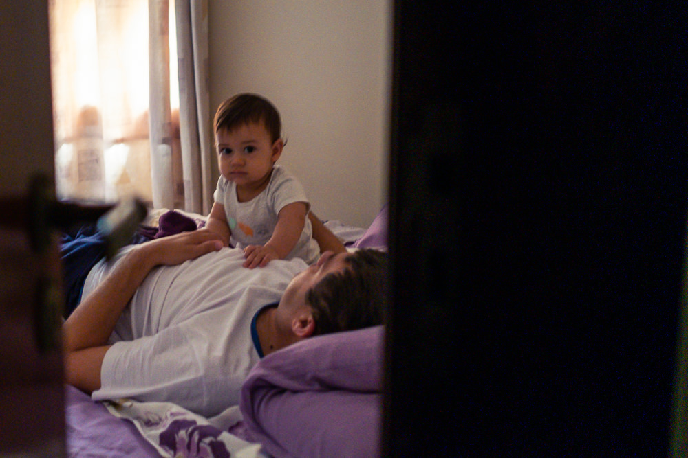 Fotografia documental de Família, Hora de acordar, pai, mãe e filho criança na cama acordando. Foto em colorida em Barueri SP