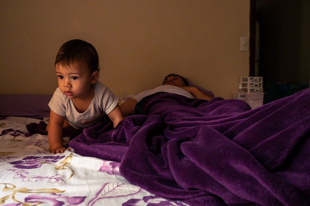 Fotografia documental de Família, Hora de acordar, pai, mãe e filho criança na cama acordando. Foto em colorida em Barueri SP