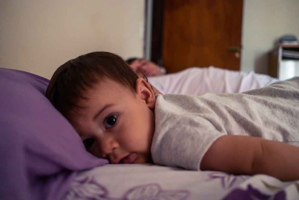 Fotografia documental de Família, Hora de acordar, pai, mãe e filho criança na cama acordando. Foto em colorida em Barueri SP