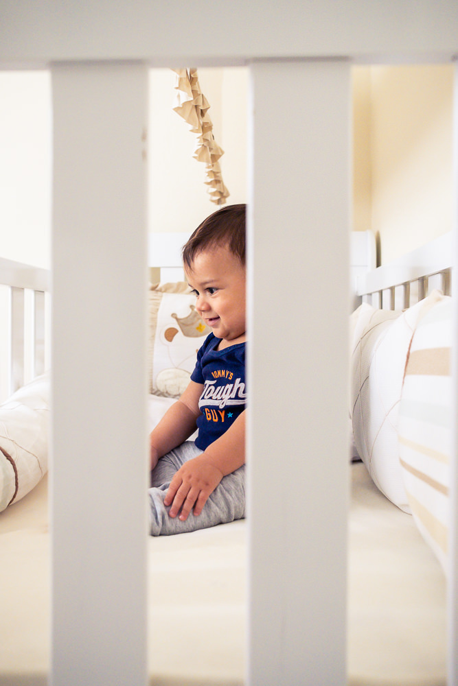 Fotografia Documental de Família. Foto da rotina da família com seu filho criança bebê, mostrando a essência a história da família.  Foto em Barueri, SP. Bebê criança dentro do berço brincando com brinquedos.