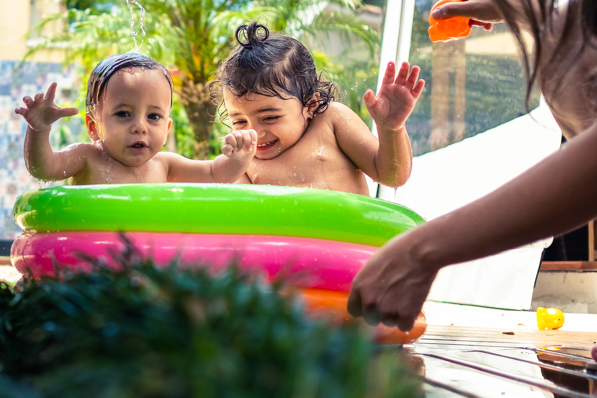 Fotografia Documental de Família em Cotia, Granja Viana, São Paulo, família Galli com filho, bebê, criança de um ano de idade. Momentos em família no café da manhã e brincando com as crianças com água. Bateria completa com os filhos.
